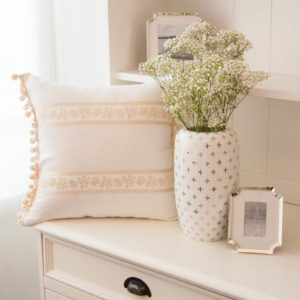 Weisses Leinen-Kissen mit Pompons und Rosen